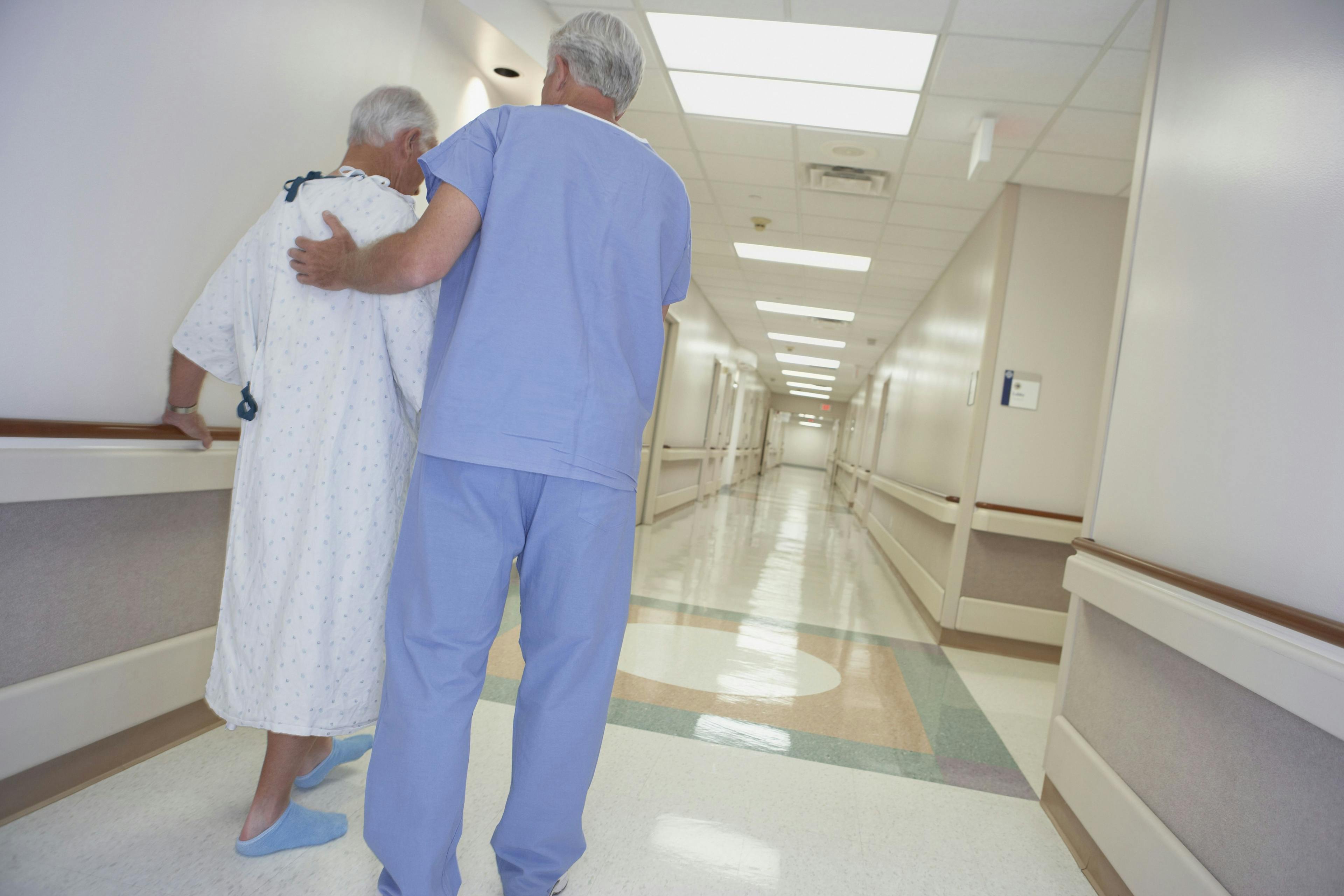 Nurse and patient walking in hospital hallway