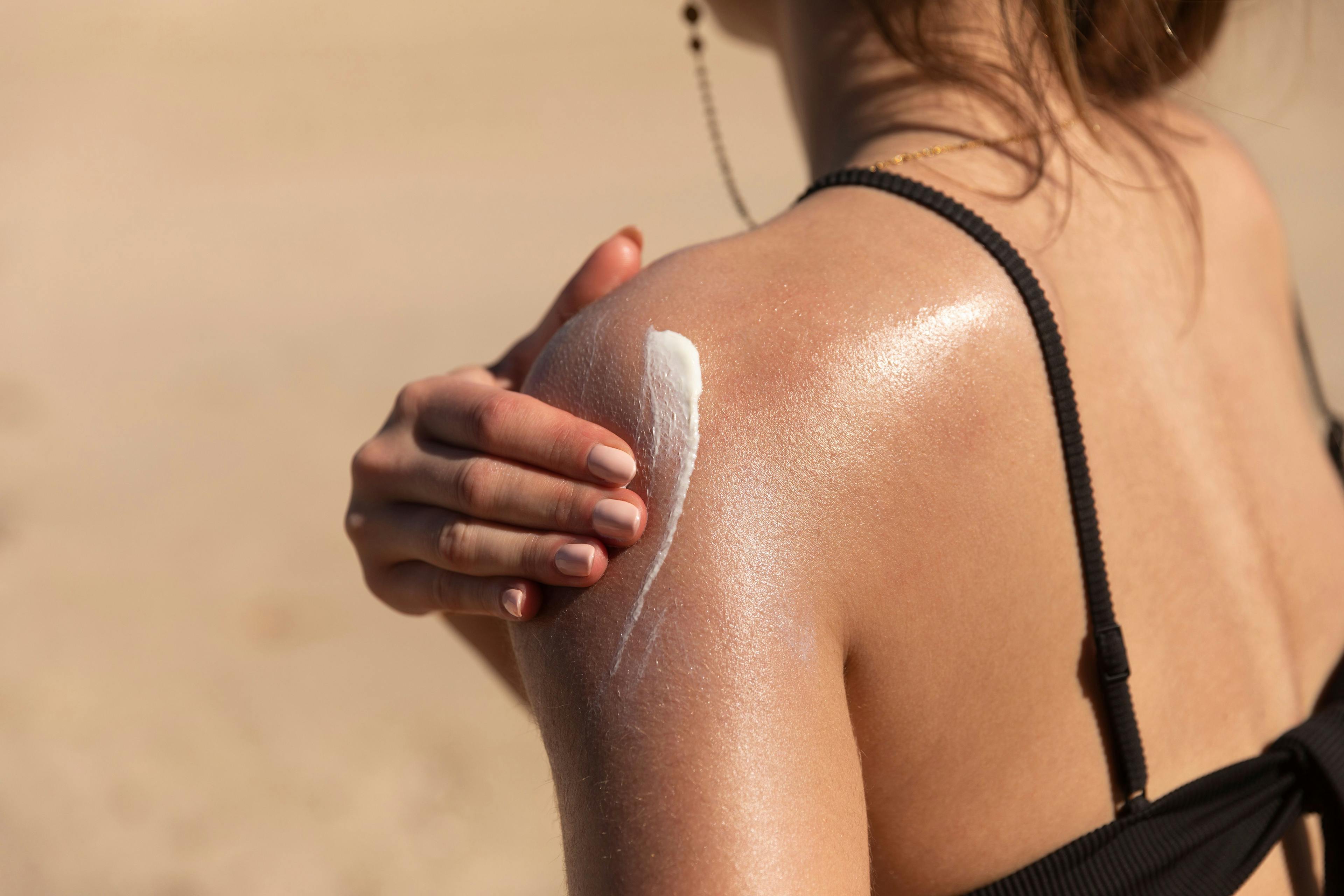 woman applying sunscreen on her shoulder | Image Credit: Lea - stock.adobe.com