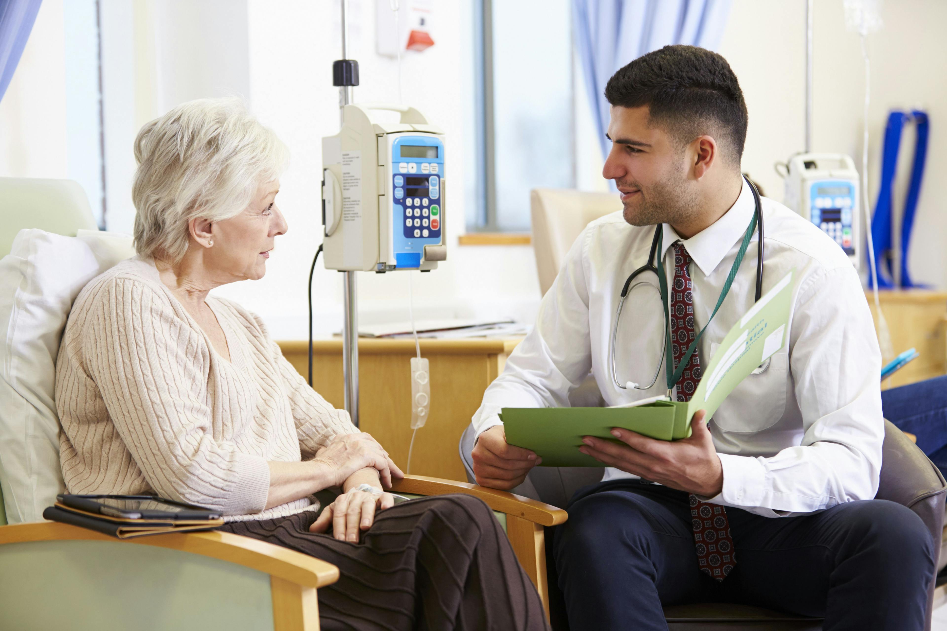 doctor speaking to woman receiving chemotherapy