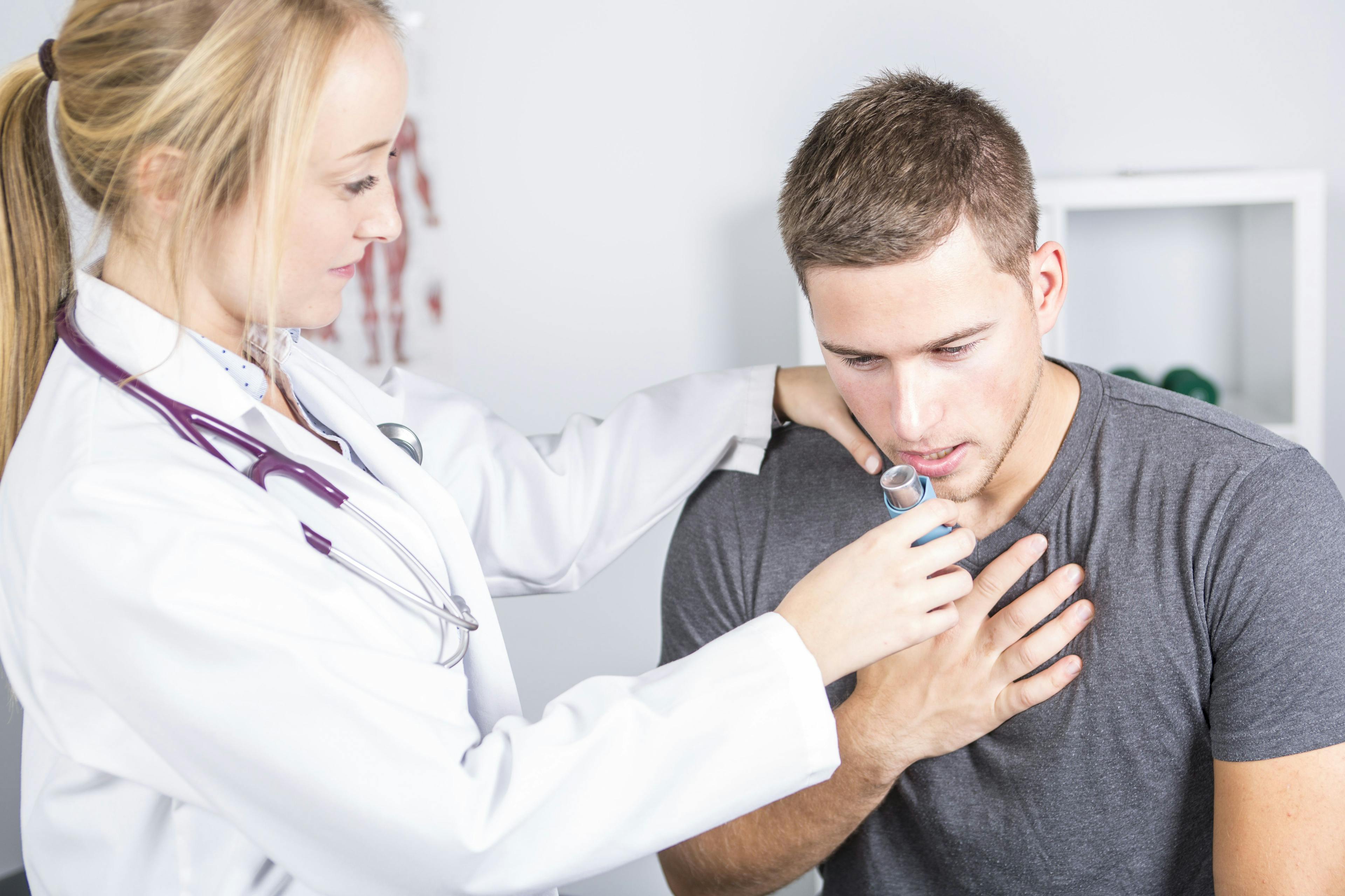 Doctor treating man with inhaler