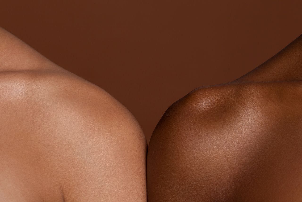 Two people's shoulders of different skin tones | Image credit: Elle Bramble/Cultura Creative - stock.adobe.com