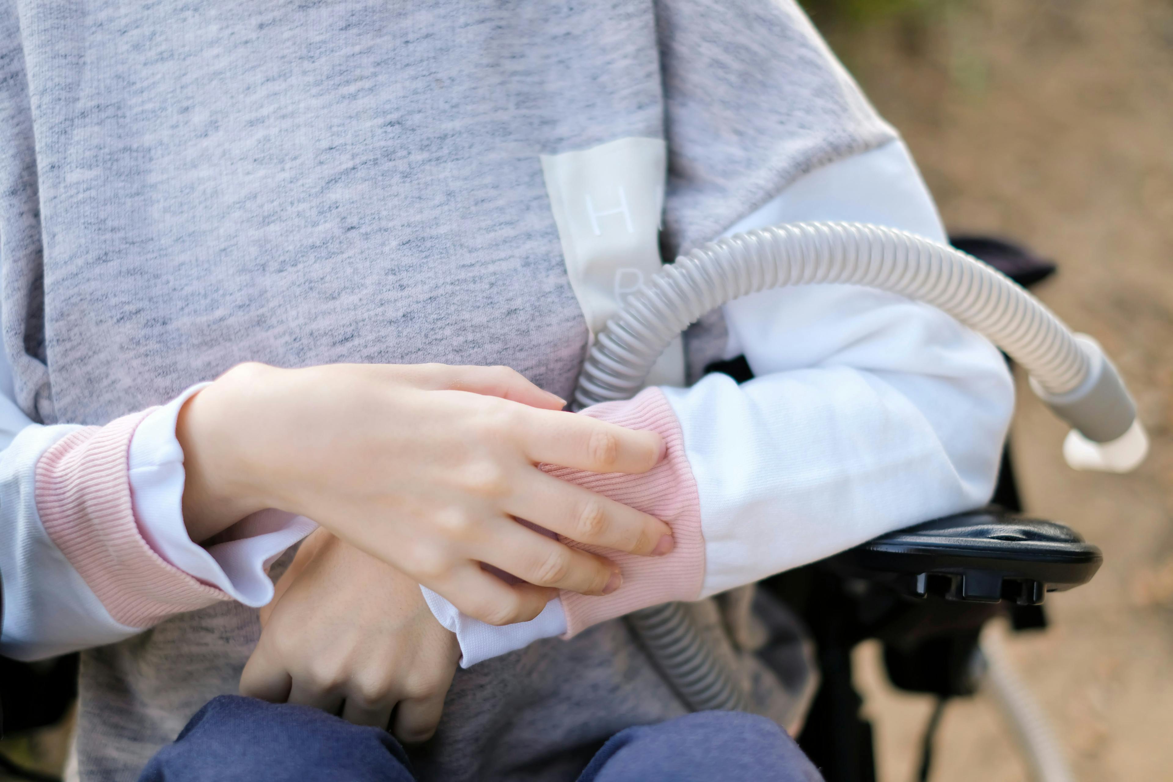 Hands of a disabled person with muscular dystrophy holding a ventilator | Image Credit: ins - stock.adobe.com