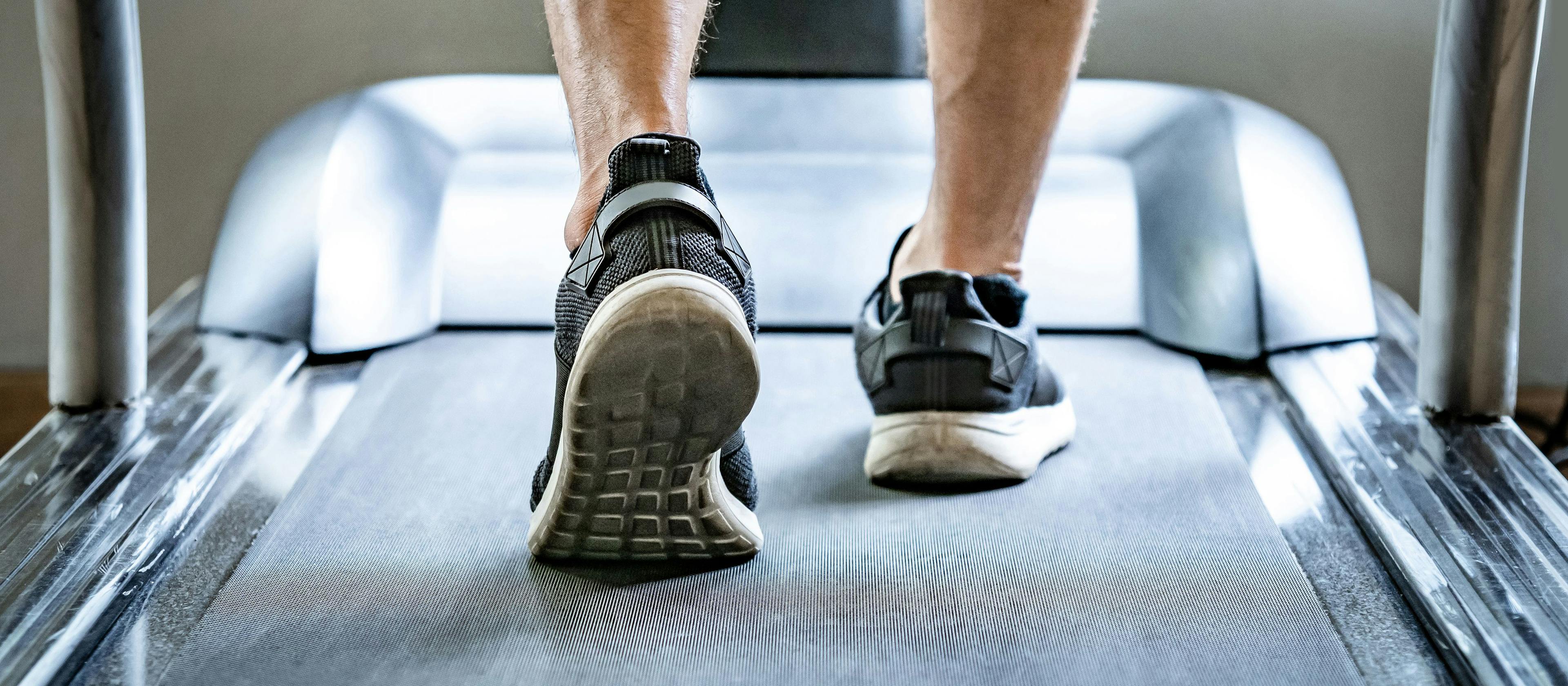 Close up of male feet in sneakers or sport footwear running on treadmill in fitness gym. Indoor cardio workout machine | Image credit: Summer Paradive - stock.adobe.com