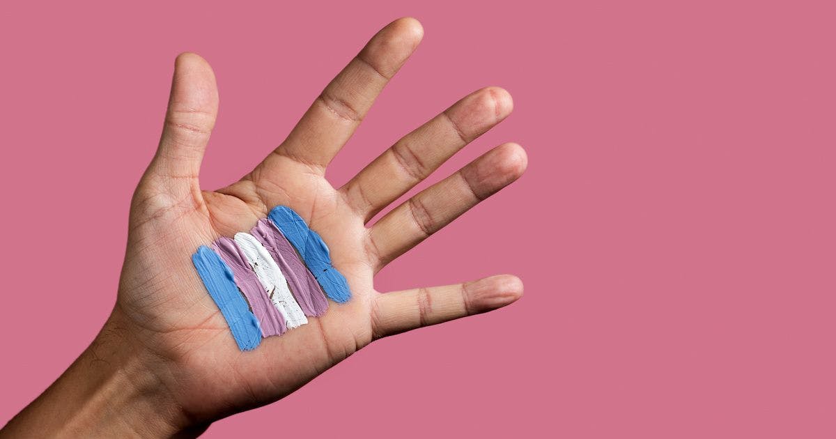 trans flag paint on hand | Image credit: Nito - stock.adobe.com.