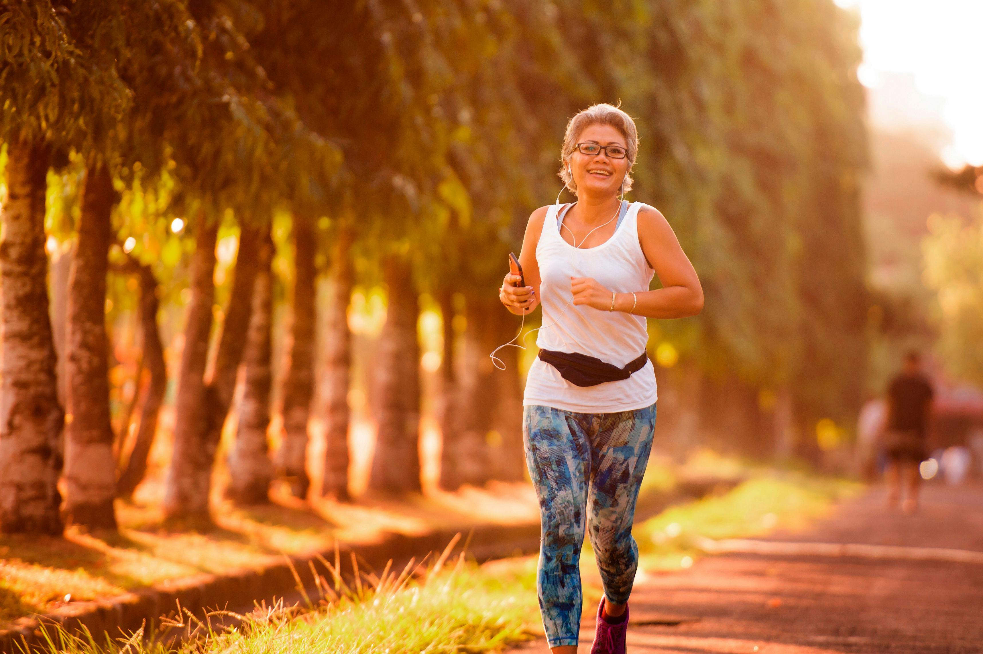 middle aged 40s or 50s happy and attractive woman with grey hair training at city park with green trees on sunrise doing running and jogging workout in health care | Image Credit: TheVisualsYouNeed – stock.adobe.com