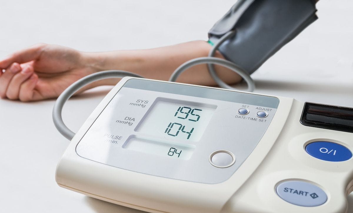 Patient measuring blood pressure with a digital monitor | Image credit: vchalup-stock.adobe.com