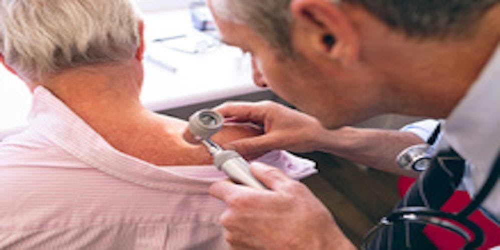 Image of a dermatologist examining a patient's skin
