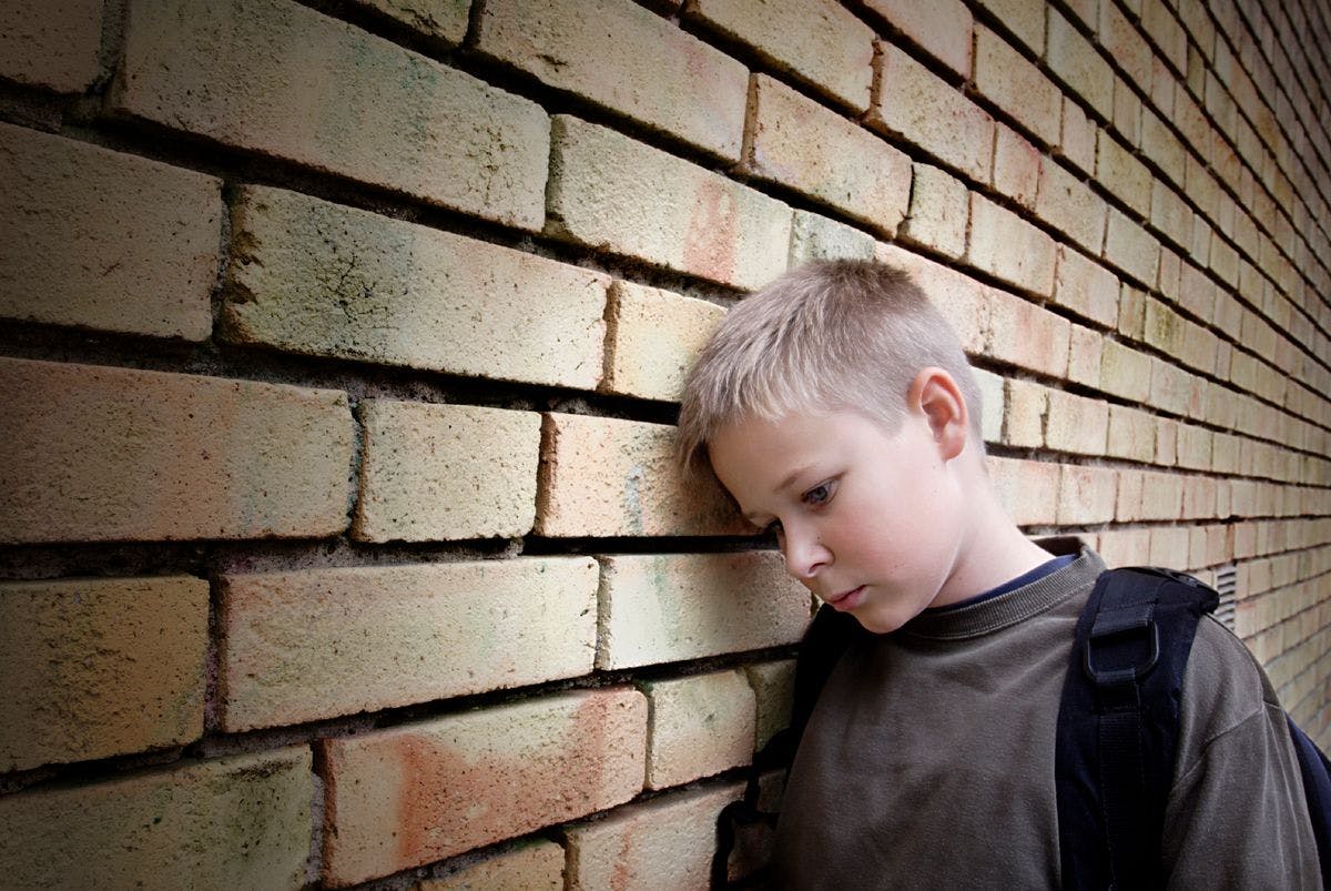 kid standing next to wall.