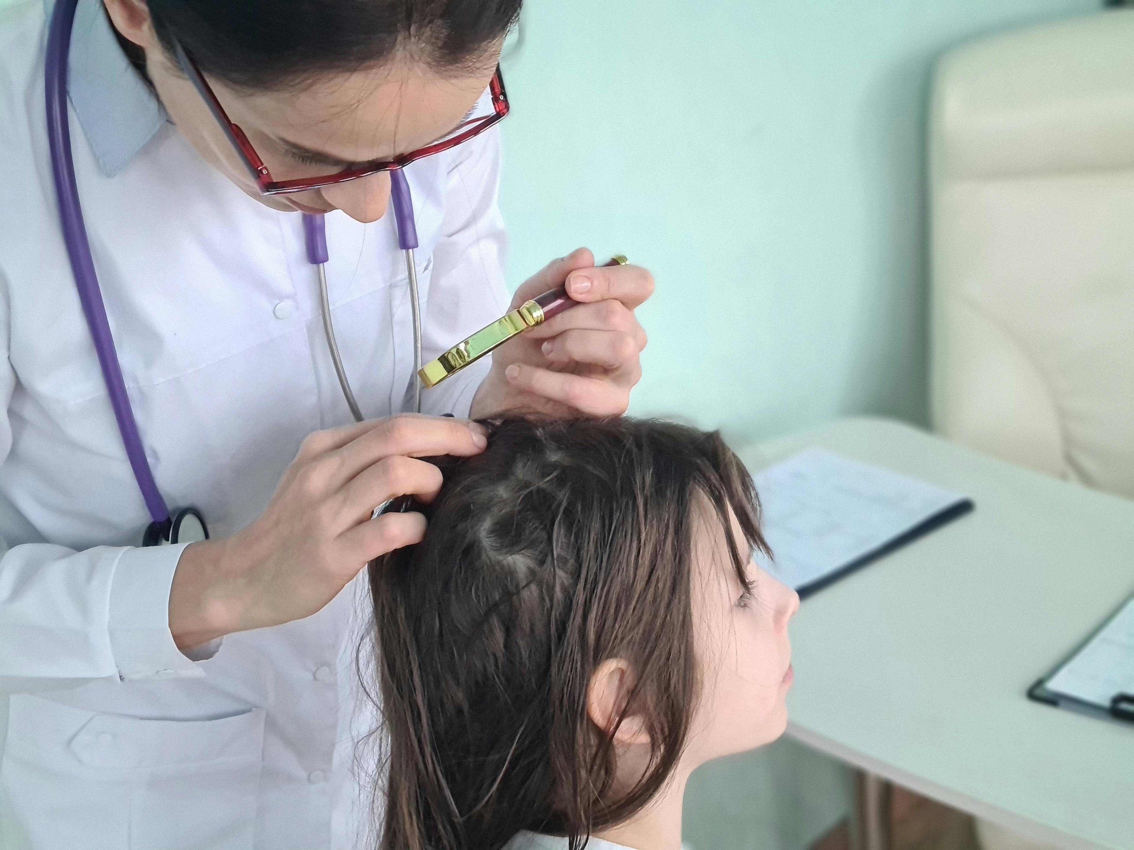 Doctor examines child scalp. | Image Credit: Nadzeya - stock.adobe.com