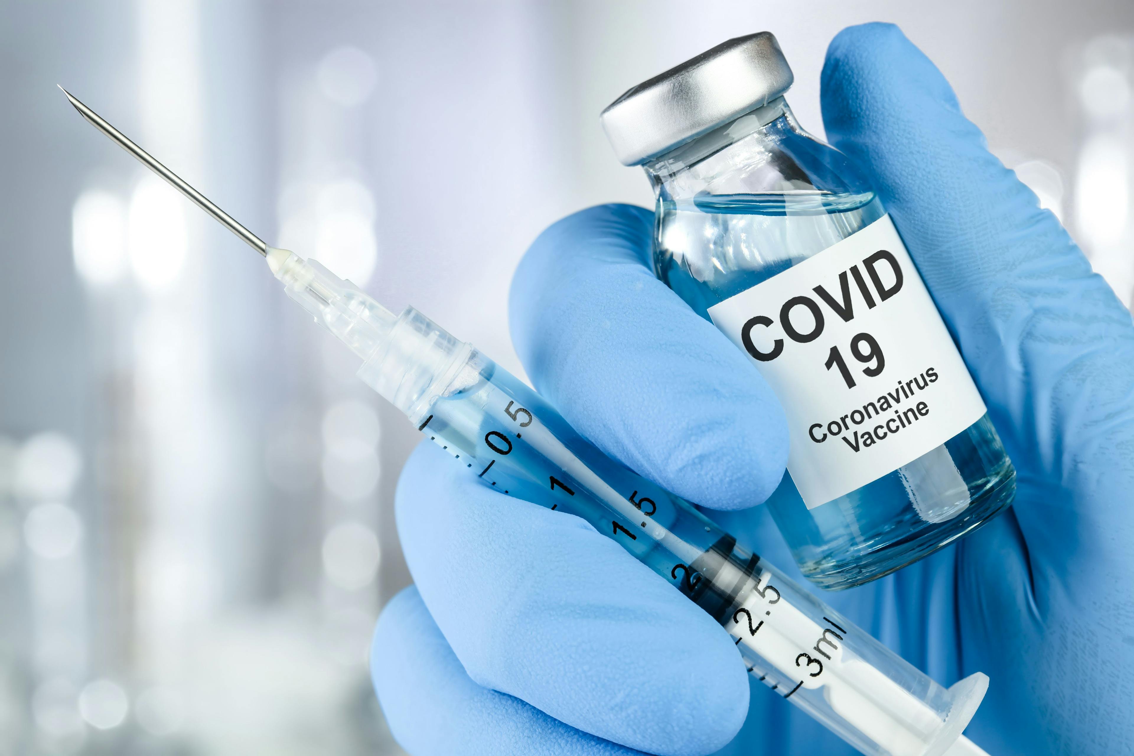 Clinician Holding COVID-19 Vaccine Bottle and Syringe | image credit: Leigh Prather - stock.adobe.com
