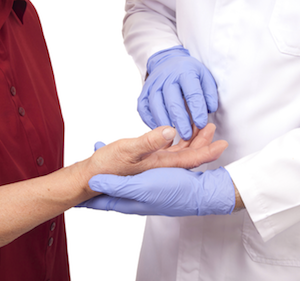 Physician examining patient palm.