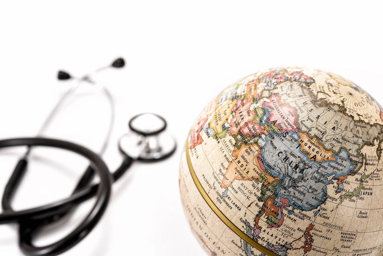 globe with Asian countries in focus with an out-of-focus stethoscope to the left