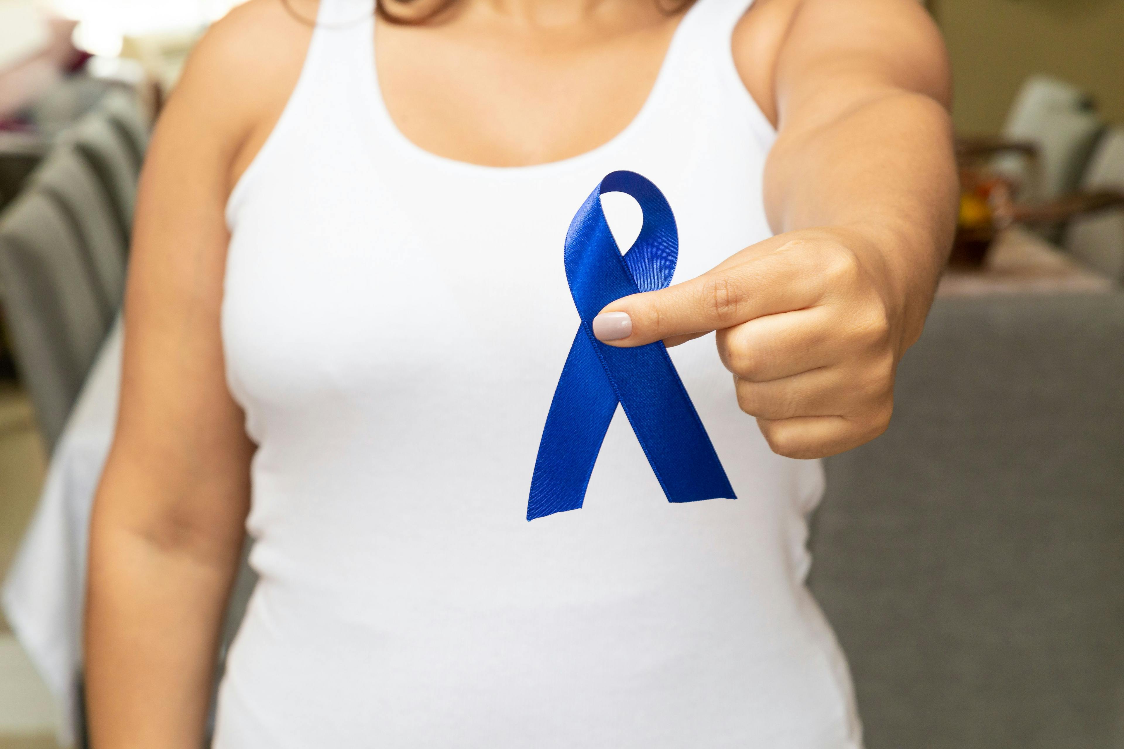 Young woman, with pink t-shirt, holding blue ribbon | Image credit: milenofrigatto - stock.adobe.com