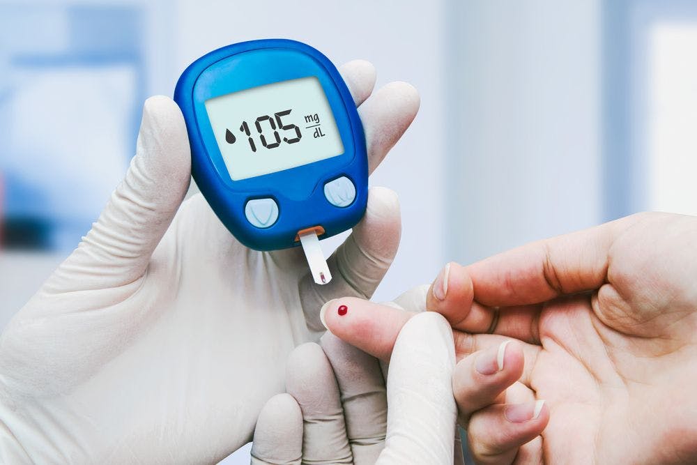 Medical personnel measuring patient's blood sugar