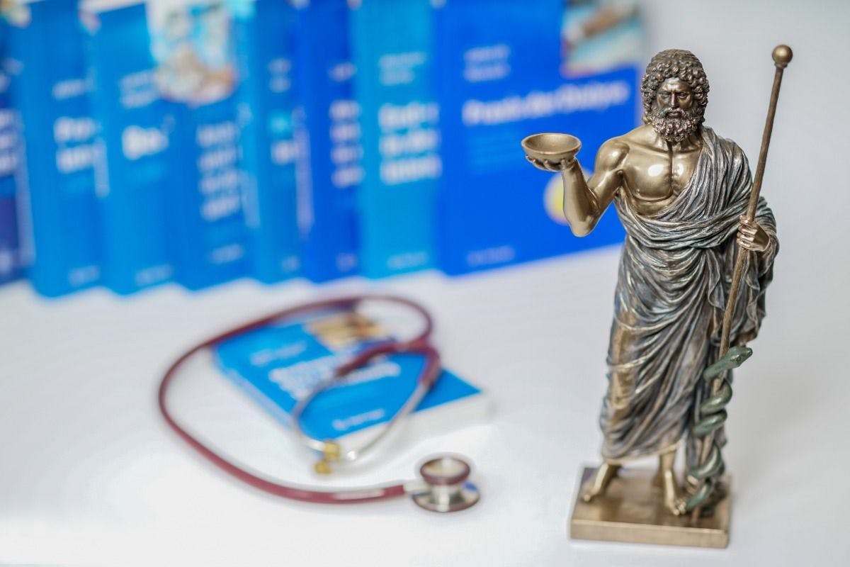 Hippocrates statue on blured medical books and stethoscope background | Image Credit: © ugiss - stock.adobe.com