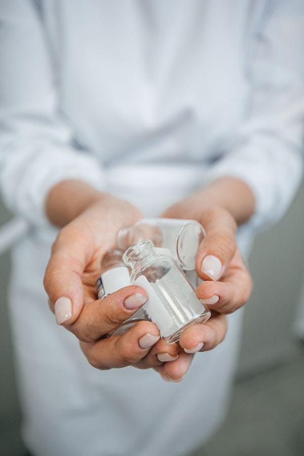 pharmacist holding empty vials | Image credit: Екатерина Рукосуева - stock.adobe.com.