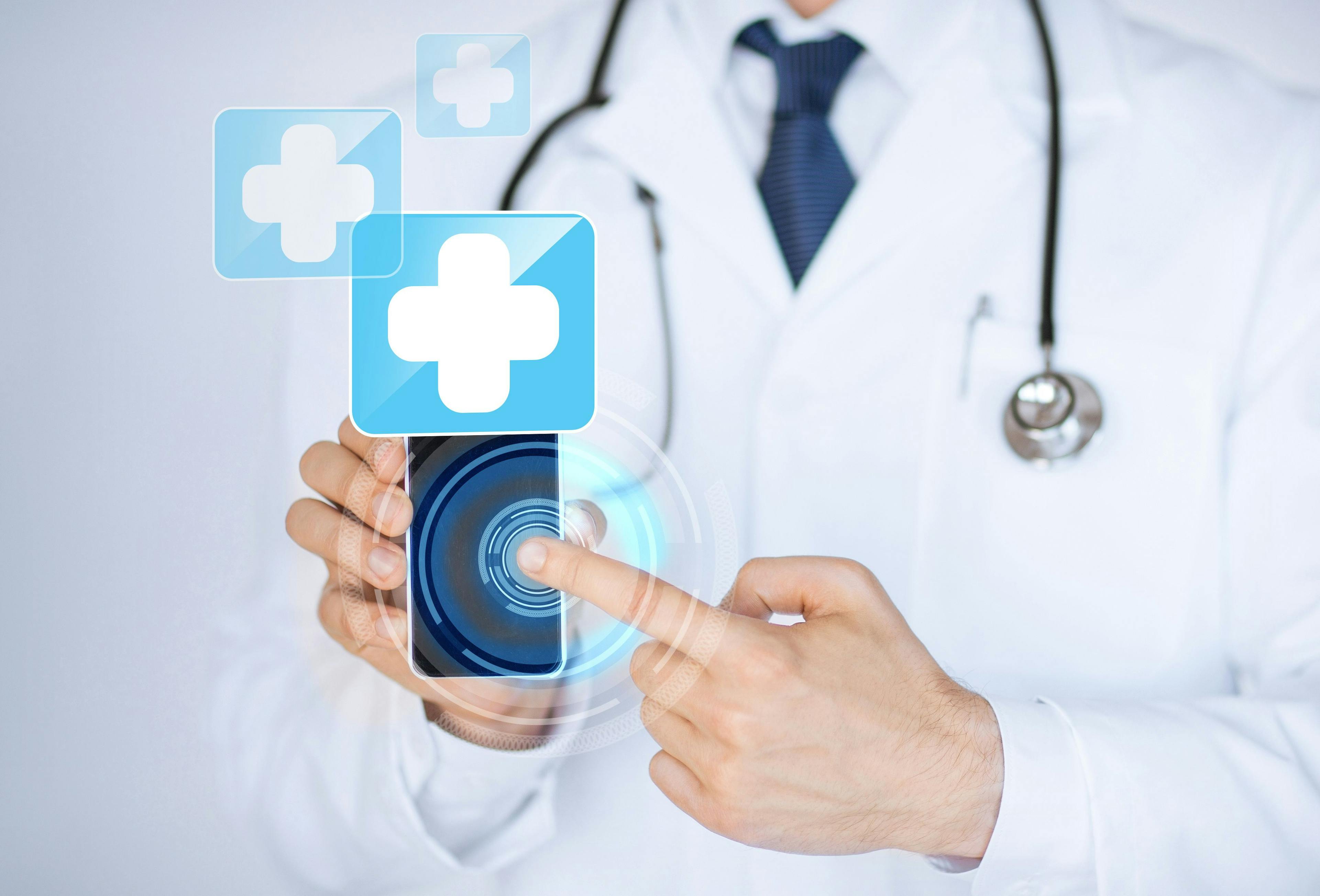 doctor holding smartphone with medical symbol on it