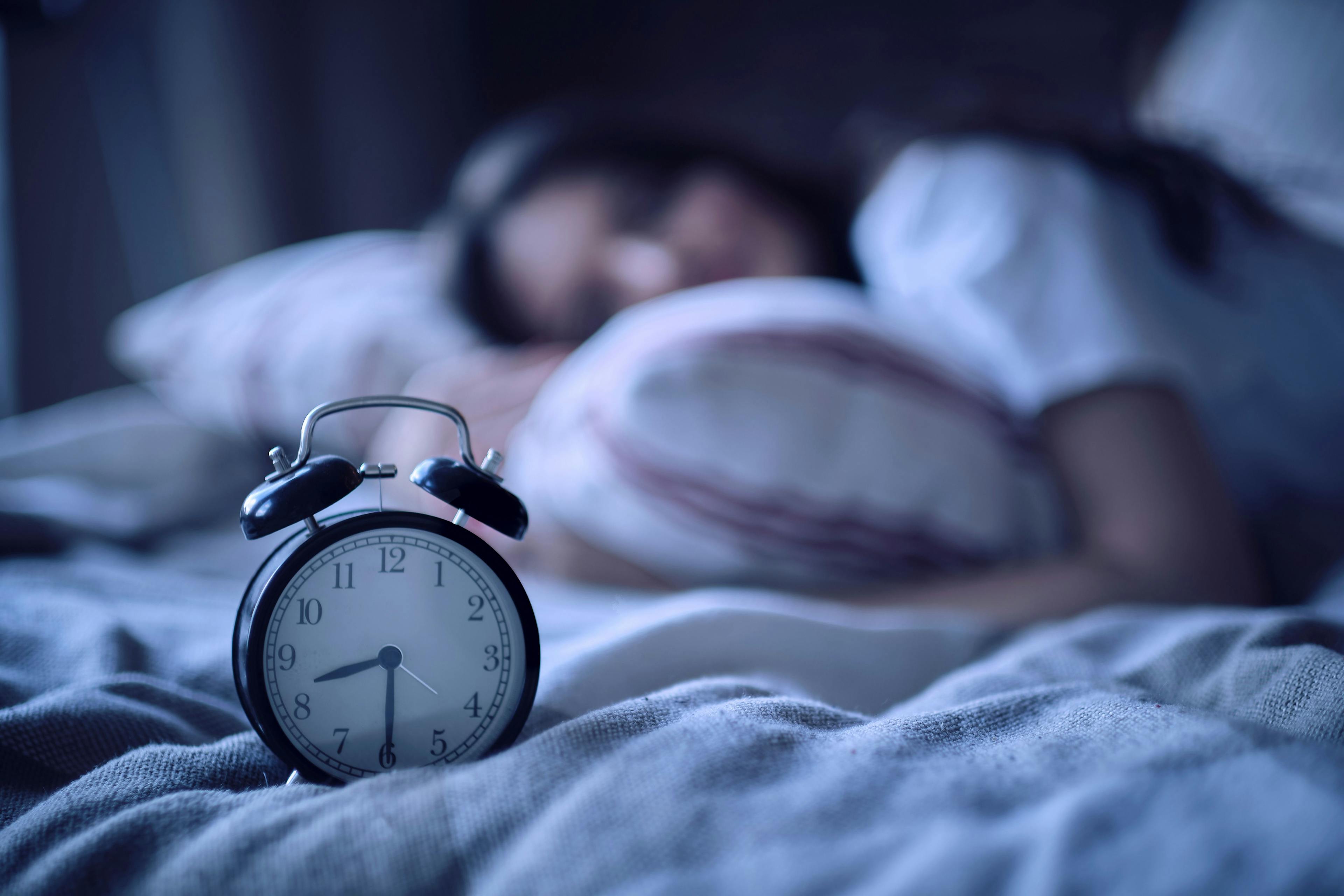 Alarm Clock Sitting Next to Dreaming Individual | image credit: yavdat - stock.adobe.com