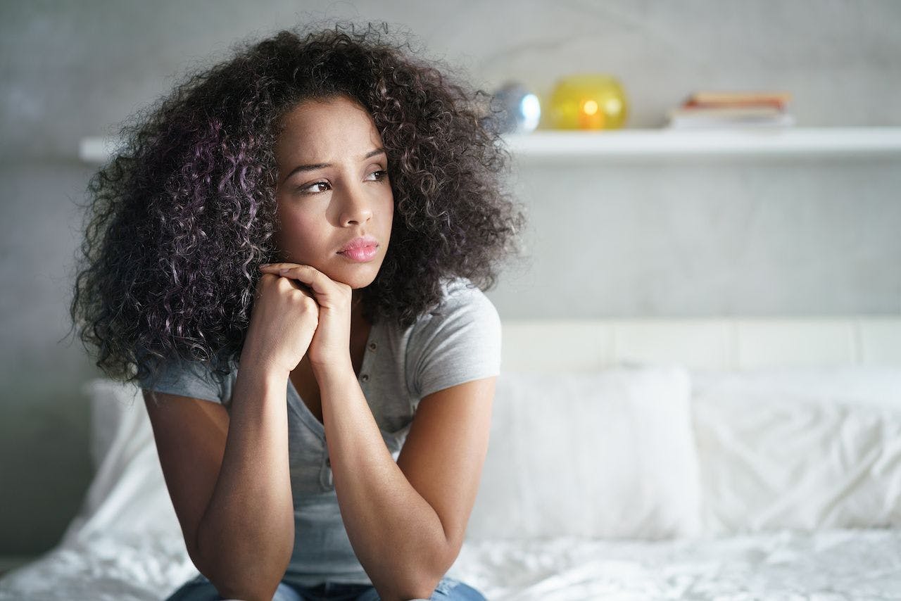Distressed young woman of color | Image credit: Diego Cervo - stock.adobe.com