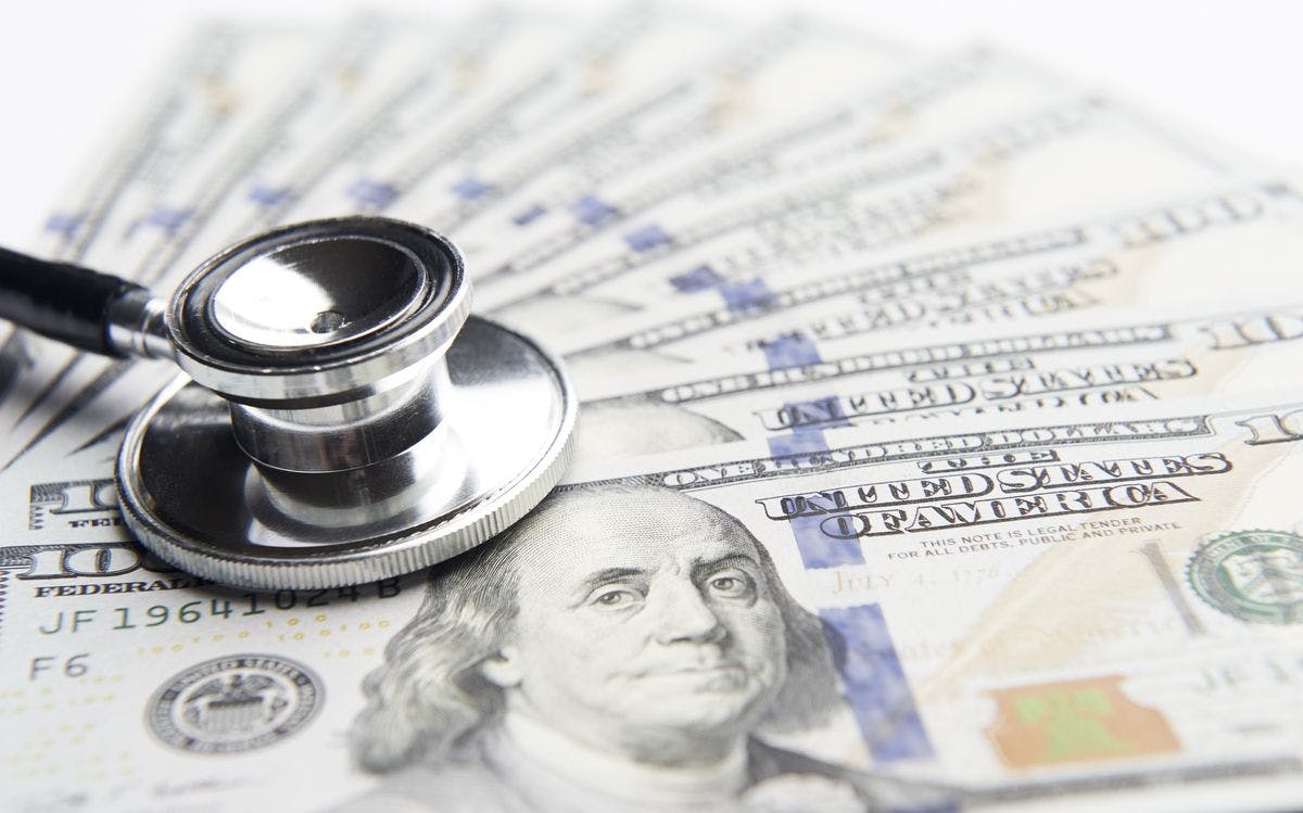 health care cost image of stethoscope lying on top of $100 bills