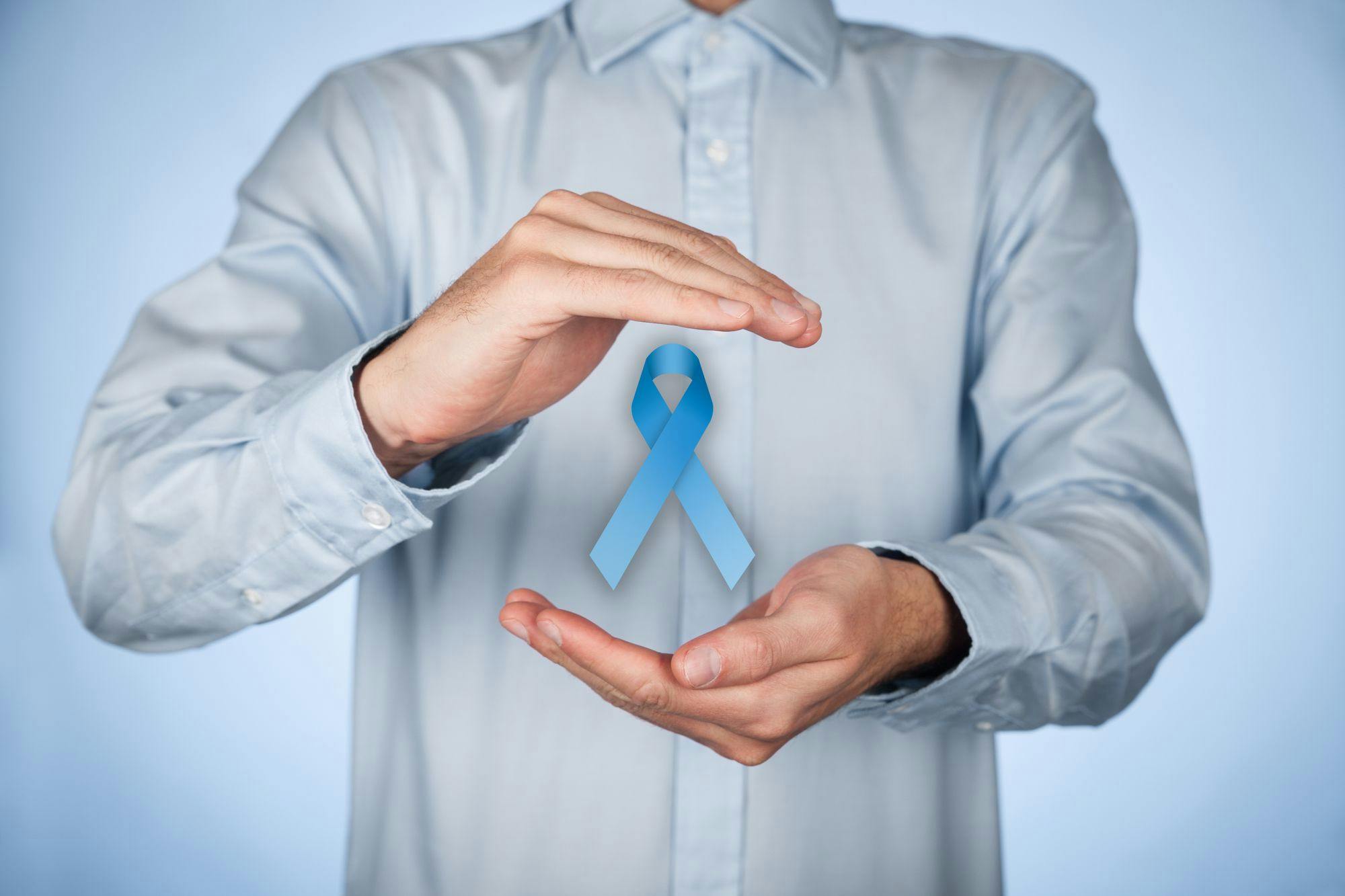 man with a blue cancer ribbon in his hands