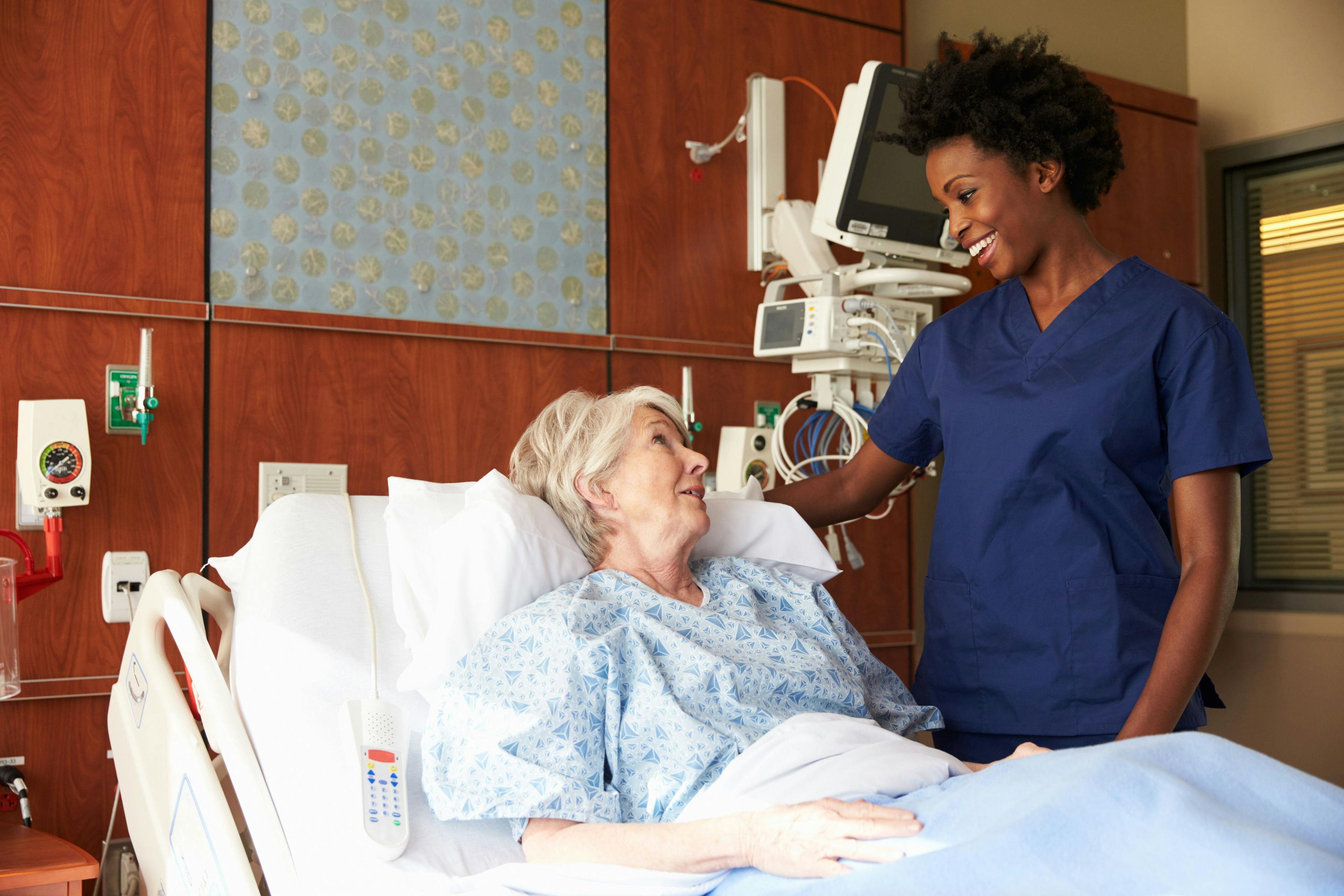 woman in a hospital bed talking to a doctor