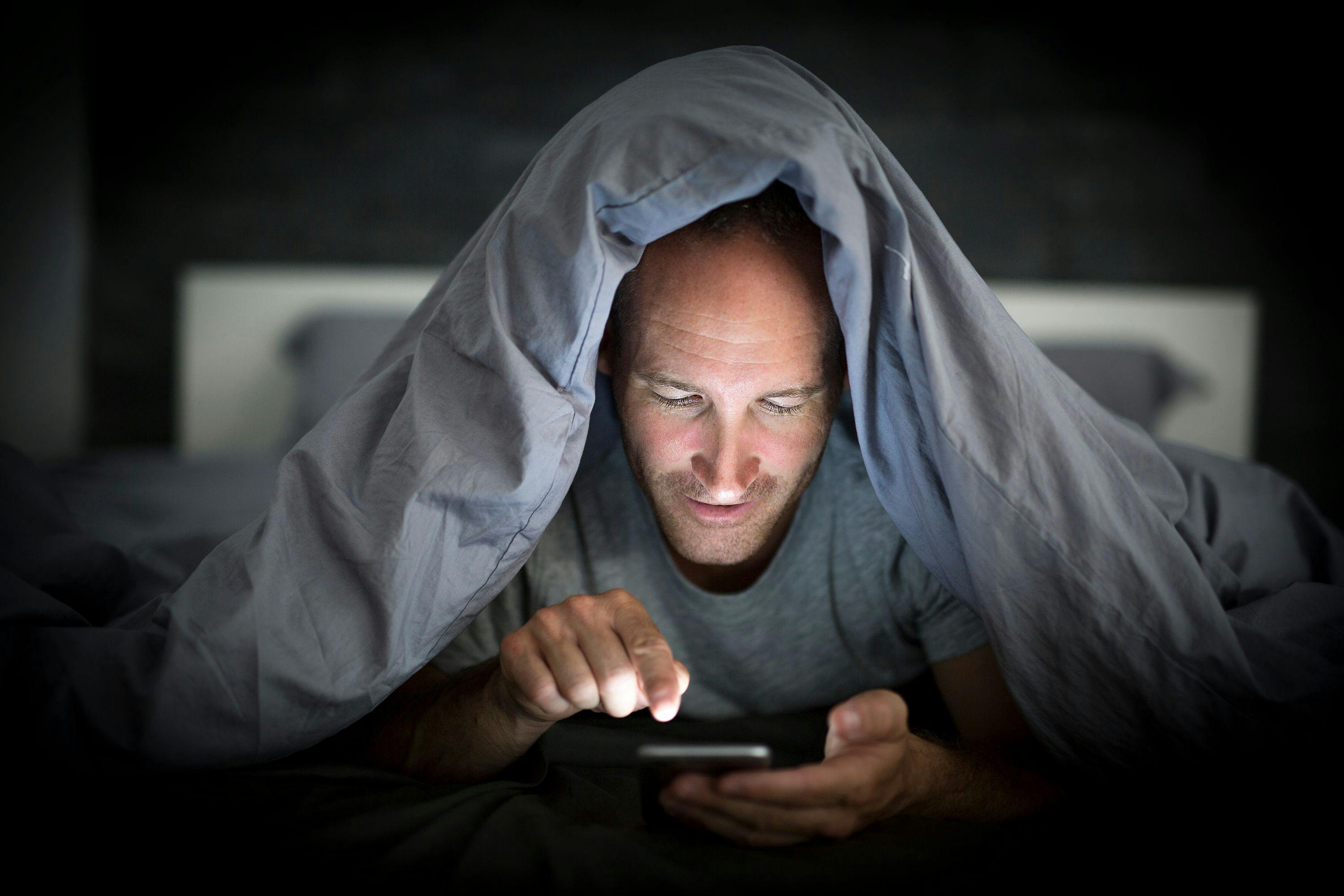 Man Endlessly Scrolling in Bed | image credit: Louis-Photo - stock.adobe.com