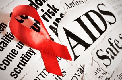 Red AIDS ribbon against newsprint