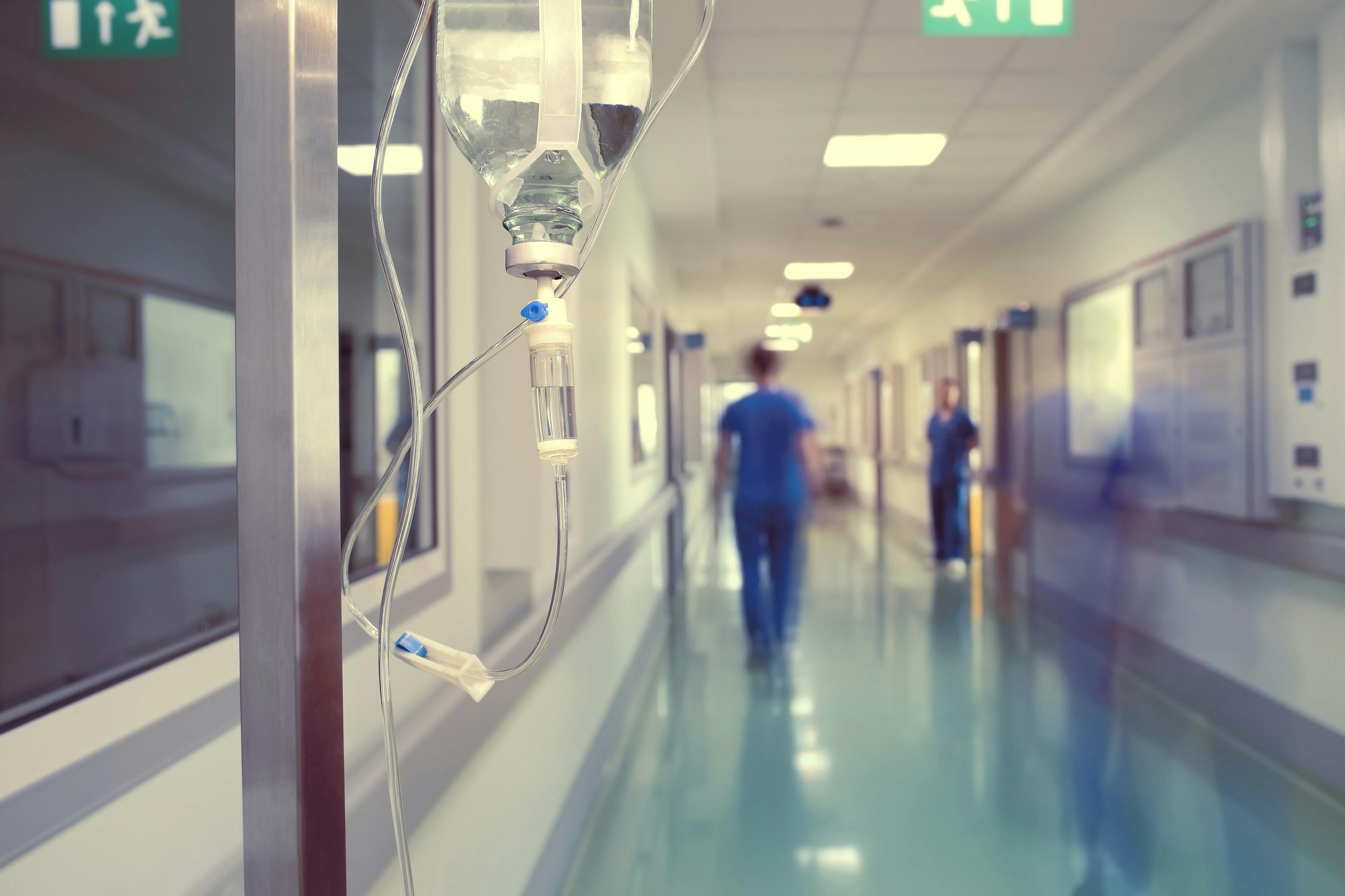 Health care worker walking in a hospital corridor.