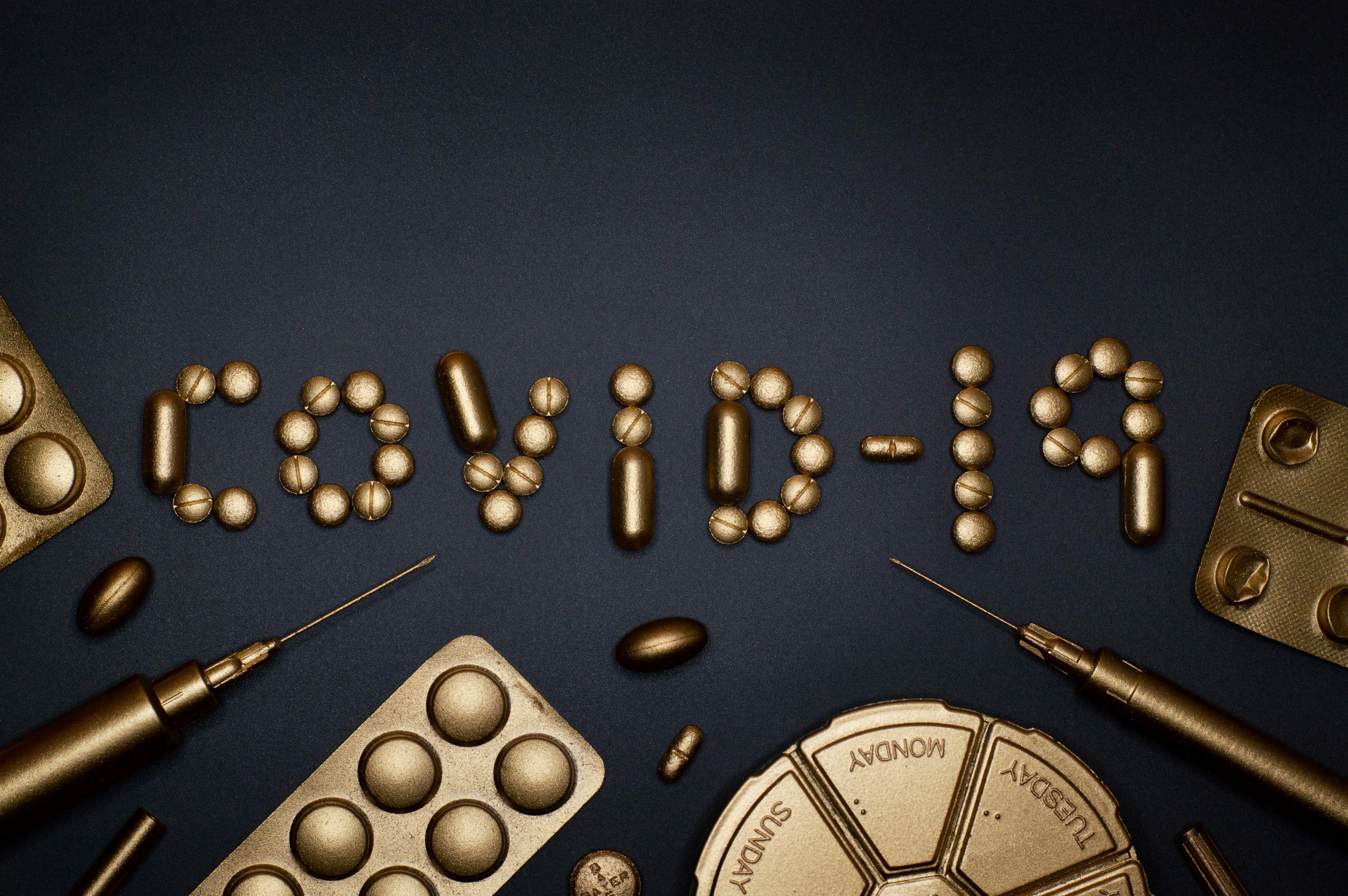"COVID-19" written in various pills surrounded by different kinds of medications