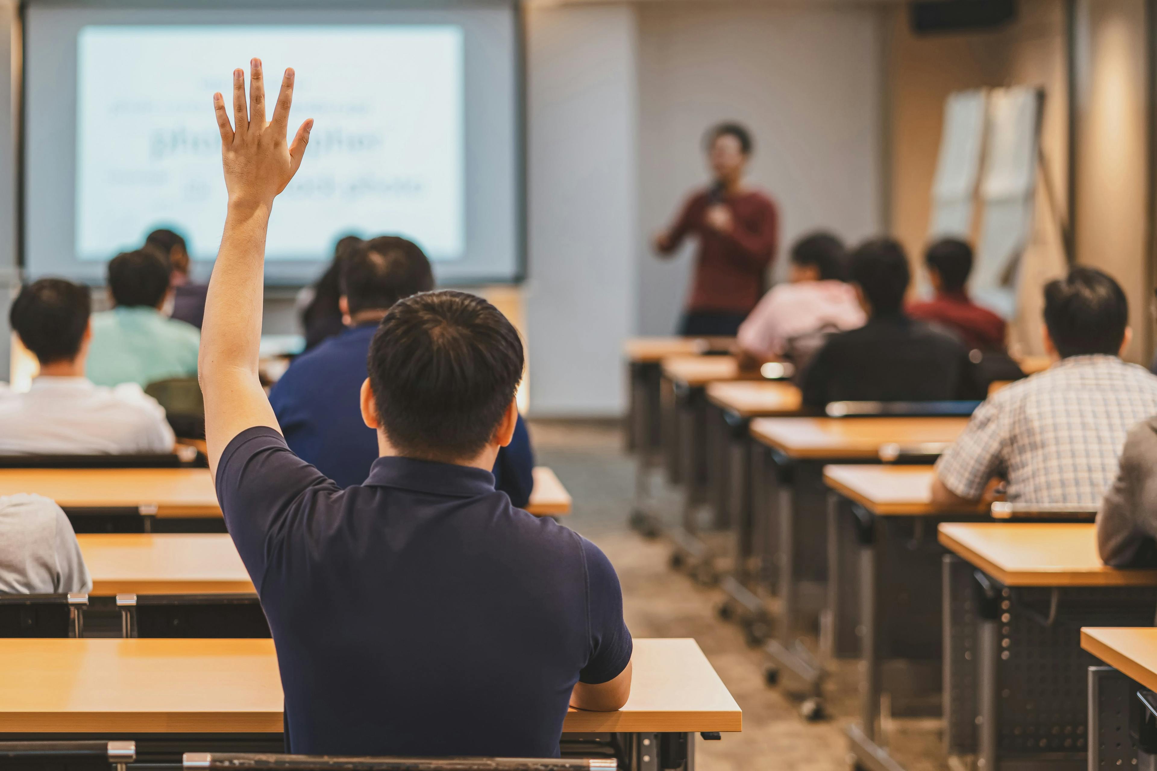 Student Raising Hand in University Classroom | image credit: THANANIT - stock.adobe.com