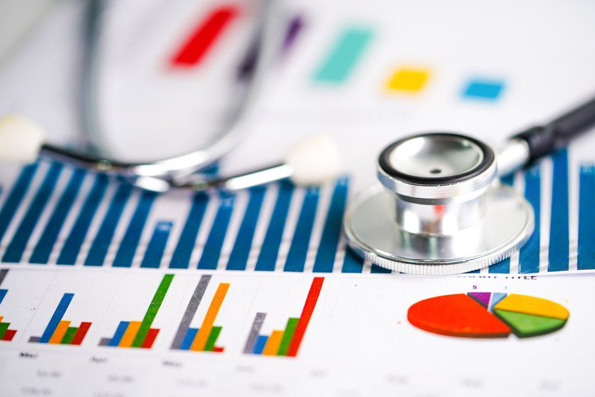 health care business pictured with stethoscope on a page of charts and graphs