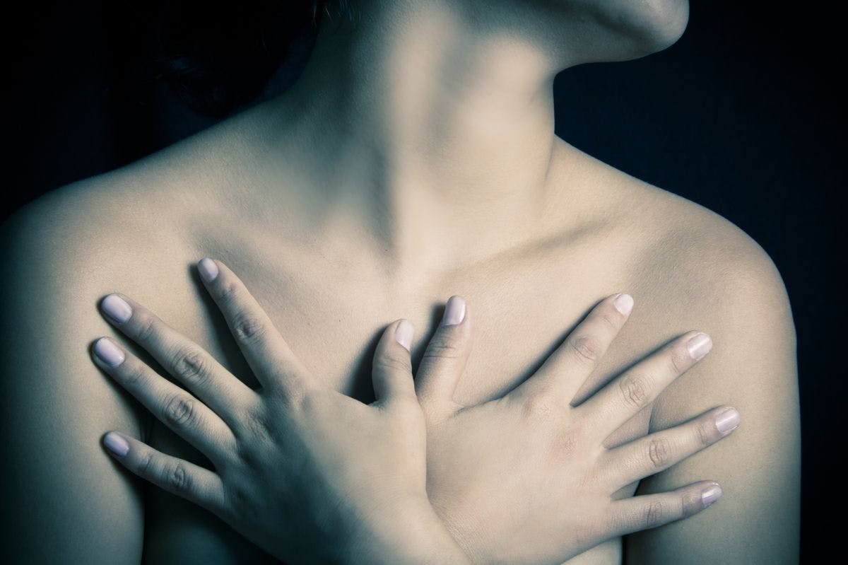 Image of a woman covering her breasts