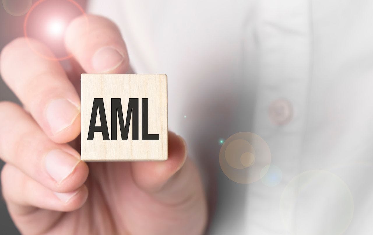 Man holding AML word on wooden cube | Image Credit: Andrey-stock.adobe.com