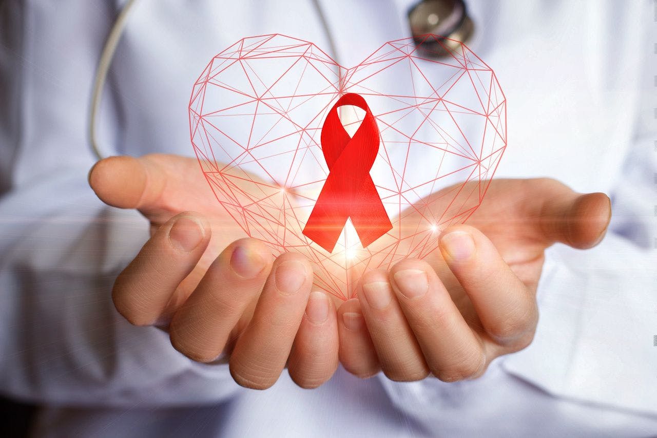 Ribbon for the fight against AIDS in the hands: © natali_mis - stock.adobe.com