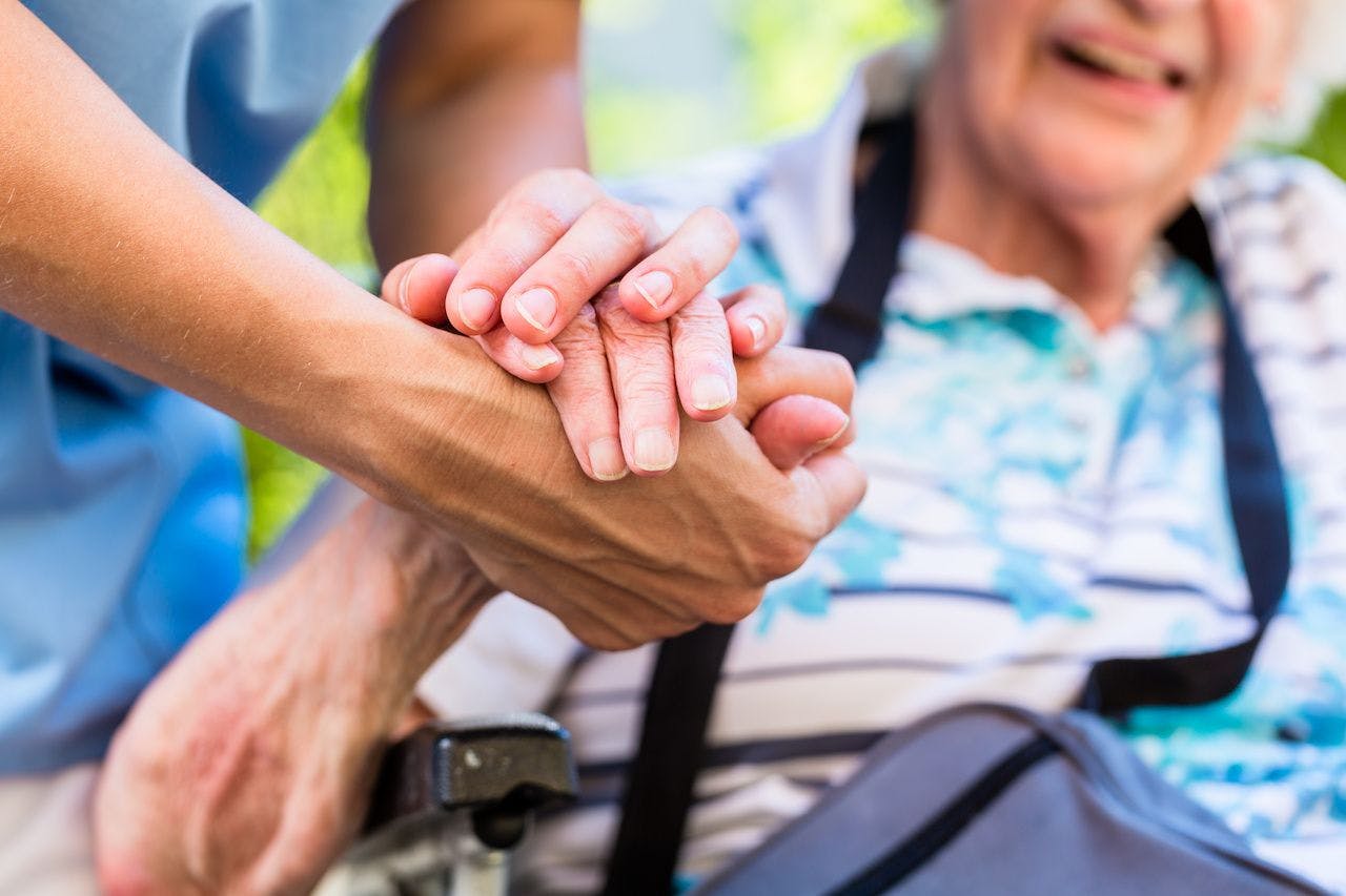 Caregiver and patients holding hands