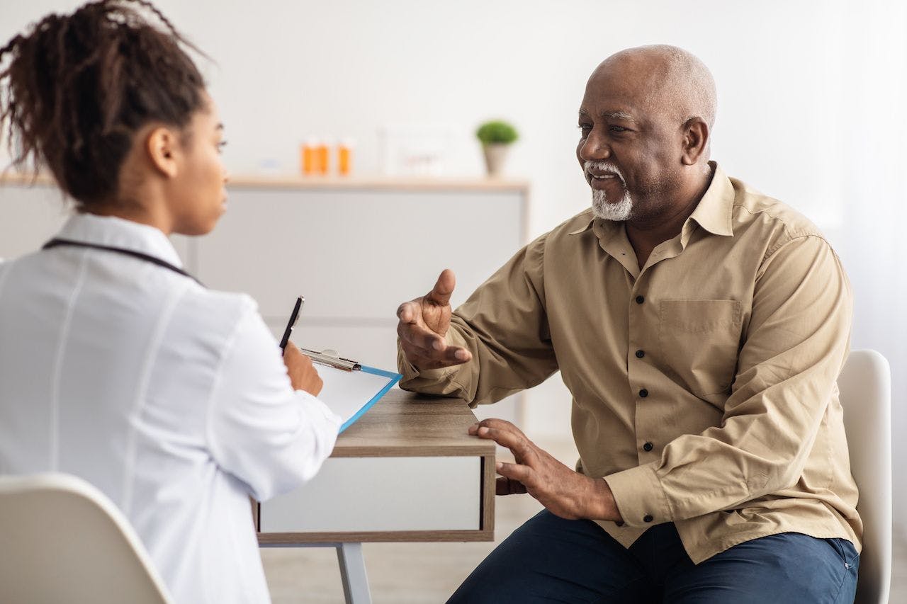 Black male patient speaking with doctor | Image credit: Clayton D/peopleimages.com - stock.adobe.com