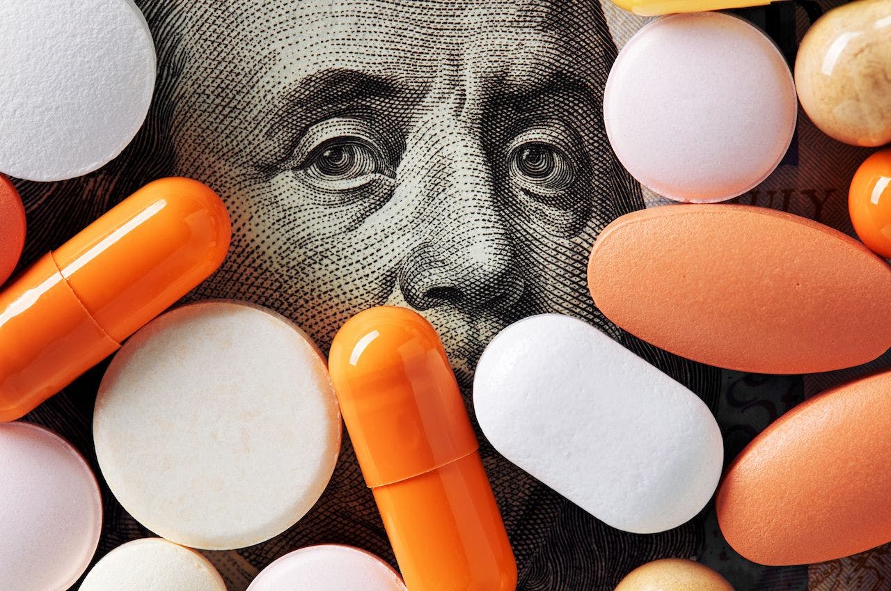 Pills on top of money | image credit: Cagkan - stock.adobe.com