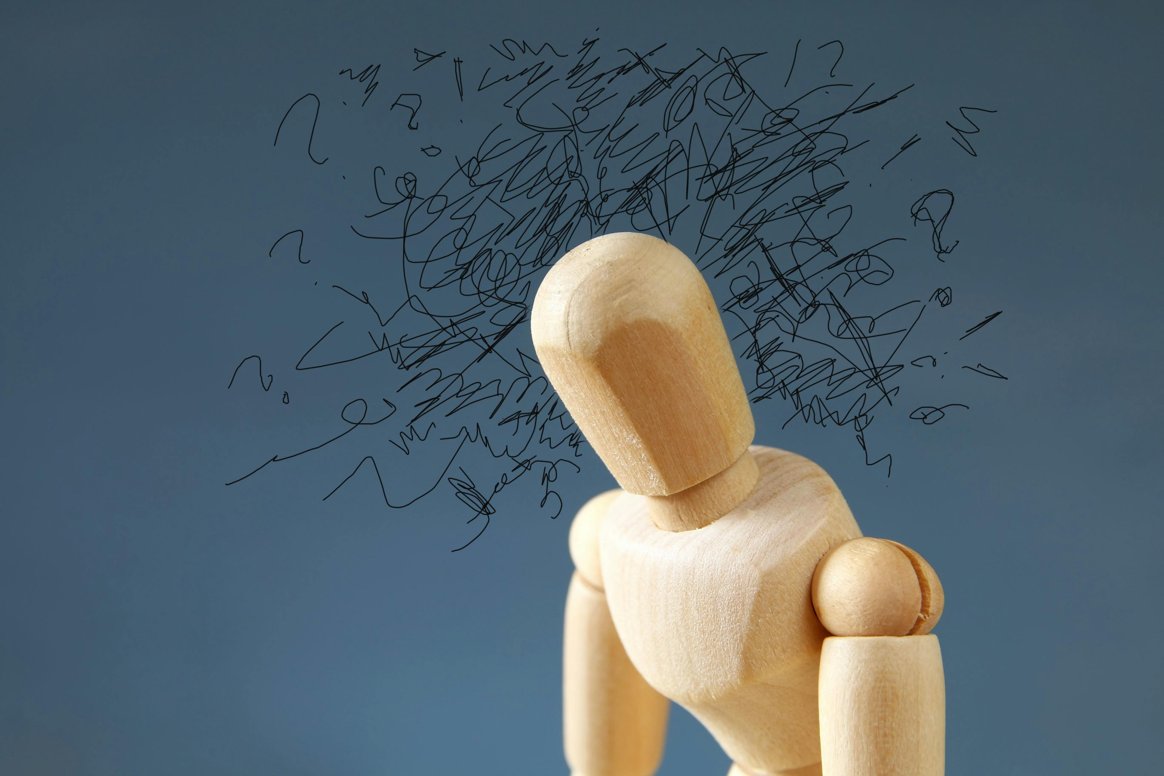 wooden human figure with scribbles around head
