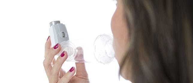 image of woman using inhaler 