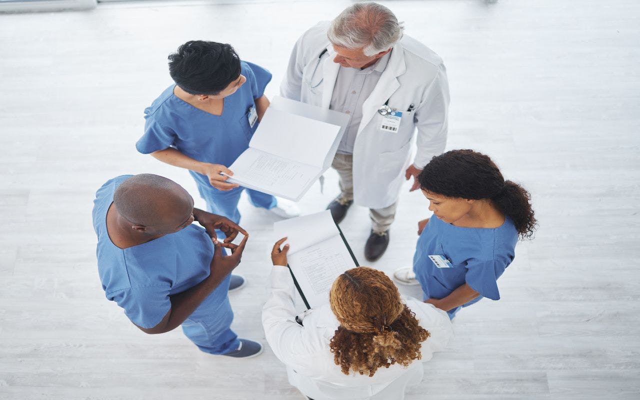 Finding solutions to complex cases from several perspectives. High angle shot of a group of medical practitioners having a discussion together in a hospital: © Kirsten D/peopleimages.com - stock.adobe.com