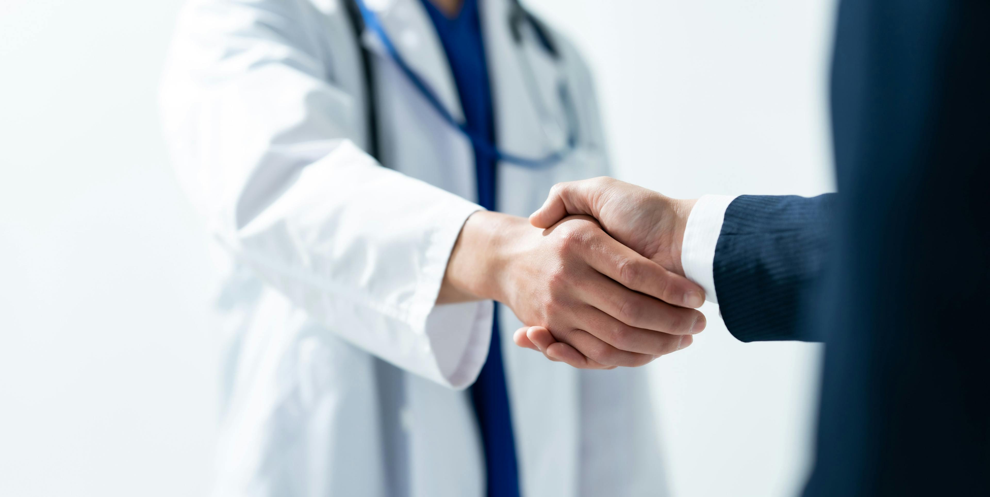 doctor and businessman shaking hands | image credit: naka – stock.adobe.com