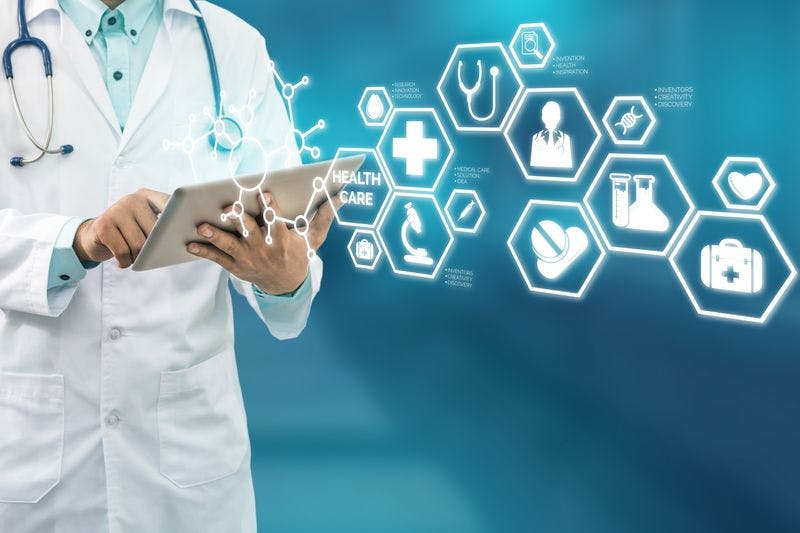 doctor with tablet as various symbols related to healthcare pass by
