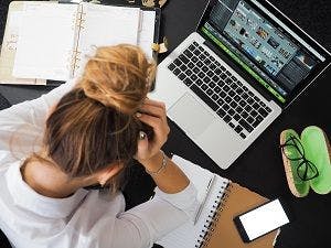 a woman is stressed at a computer