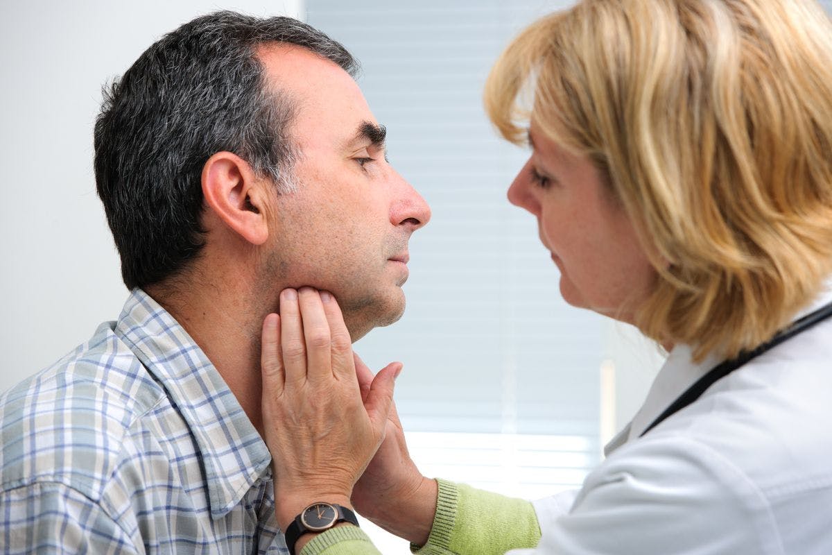 Clinician examining thyroid