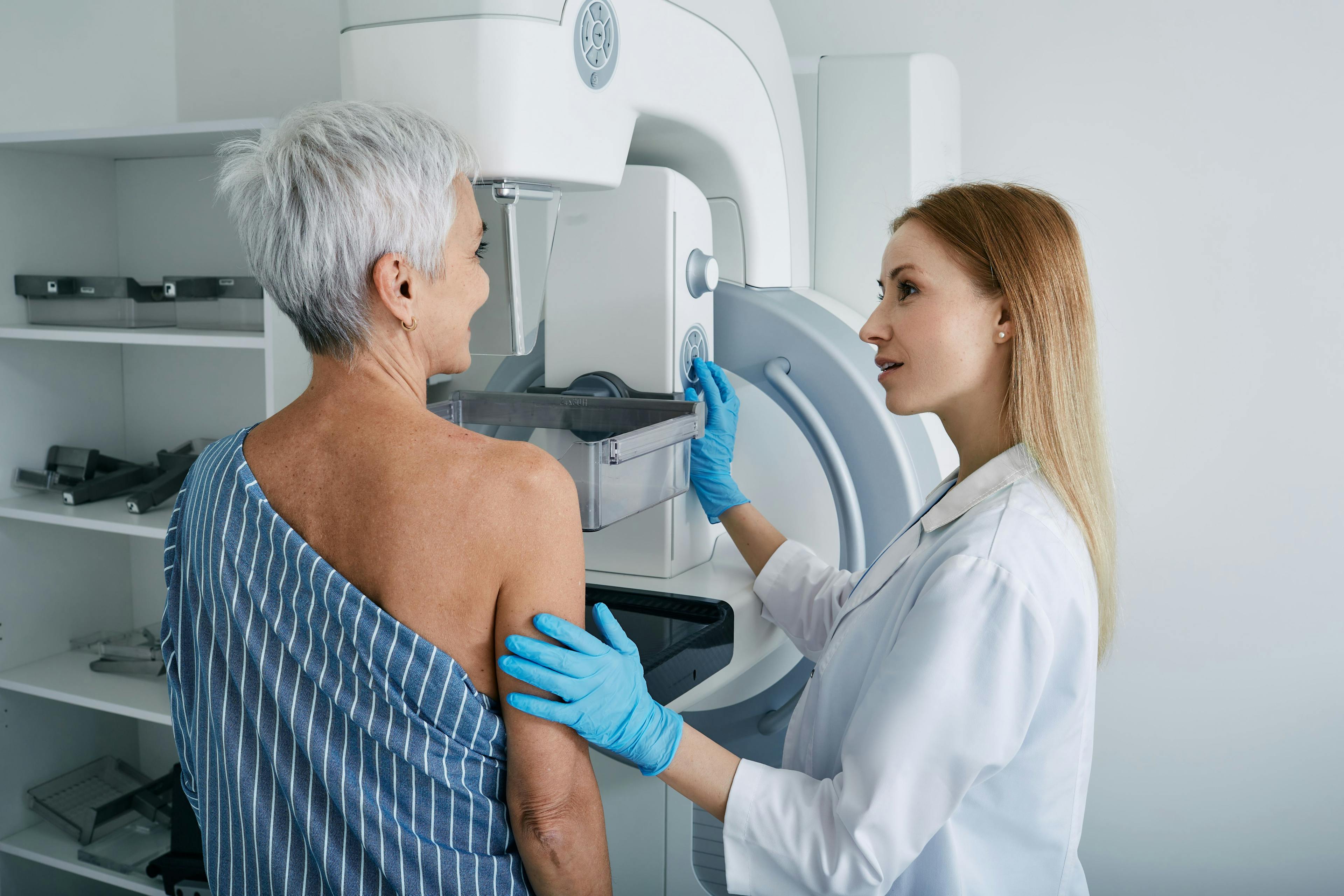 Senior woman having mammography scan at hospital with medical technician. Mammography procedure, breast cancer prevention | Image Credit:  Peakstock