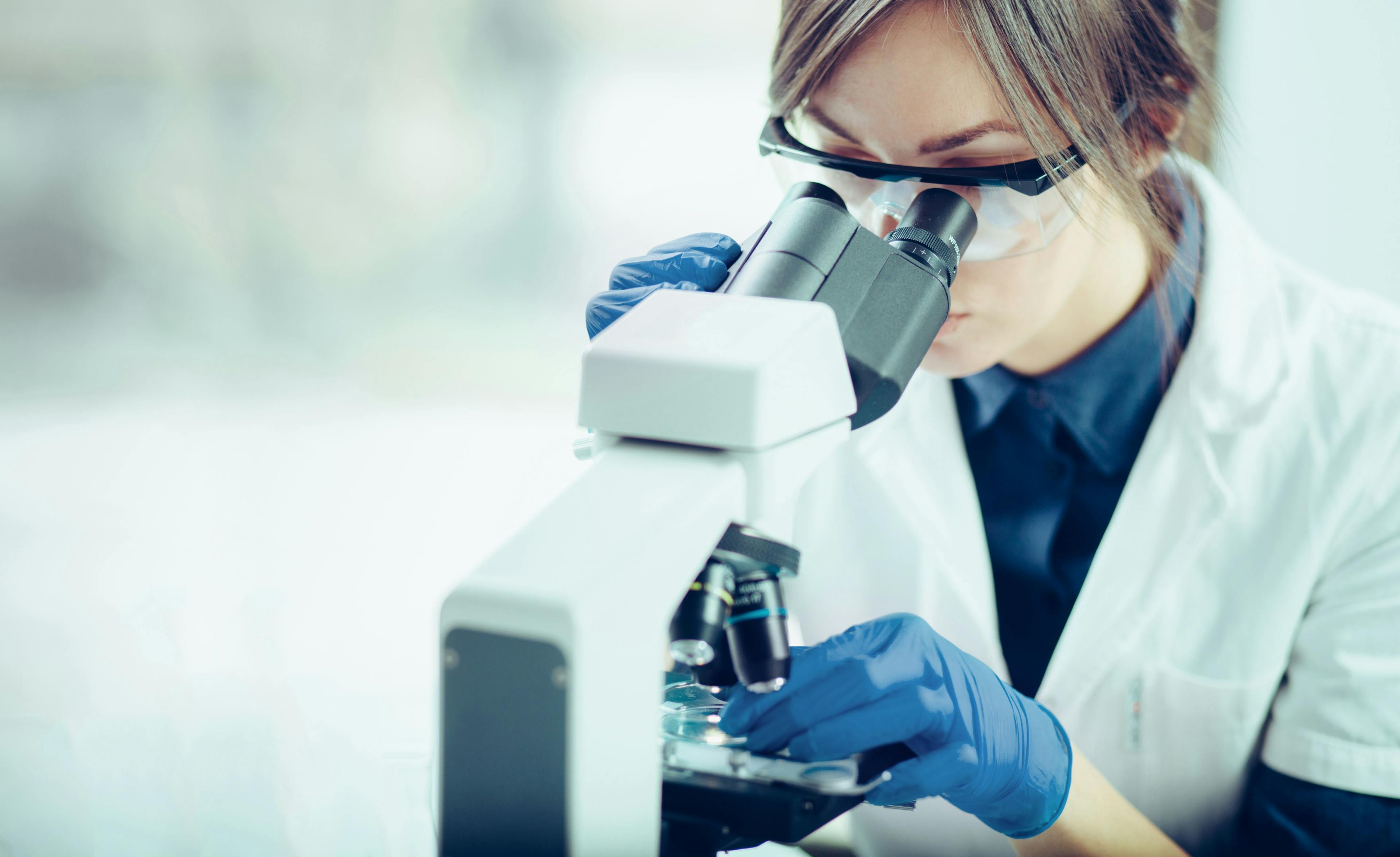 woman in a lab using a microscope