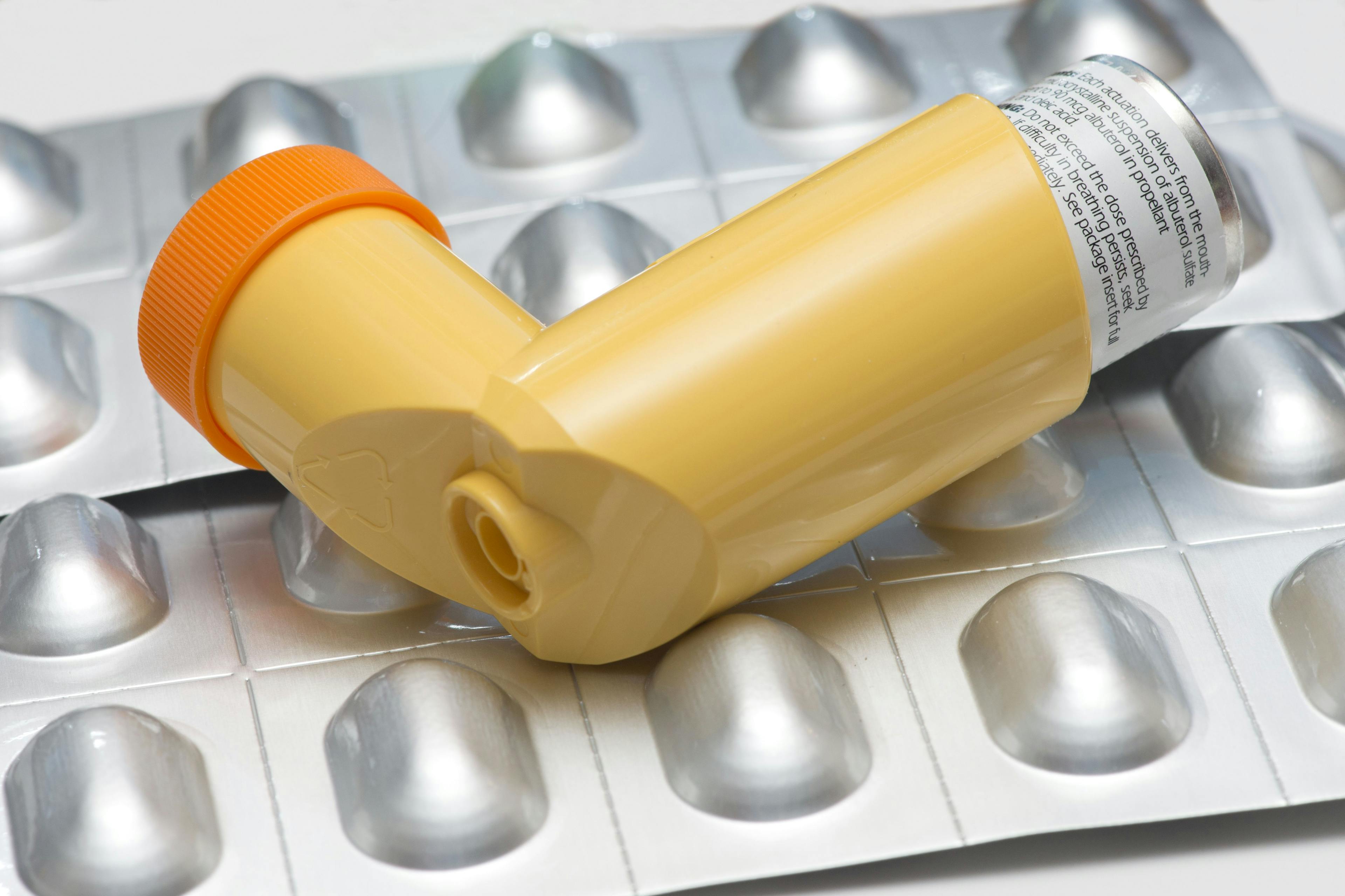 yellow inhaler placed on top of a pill sheet