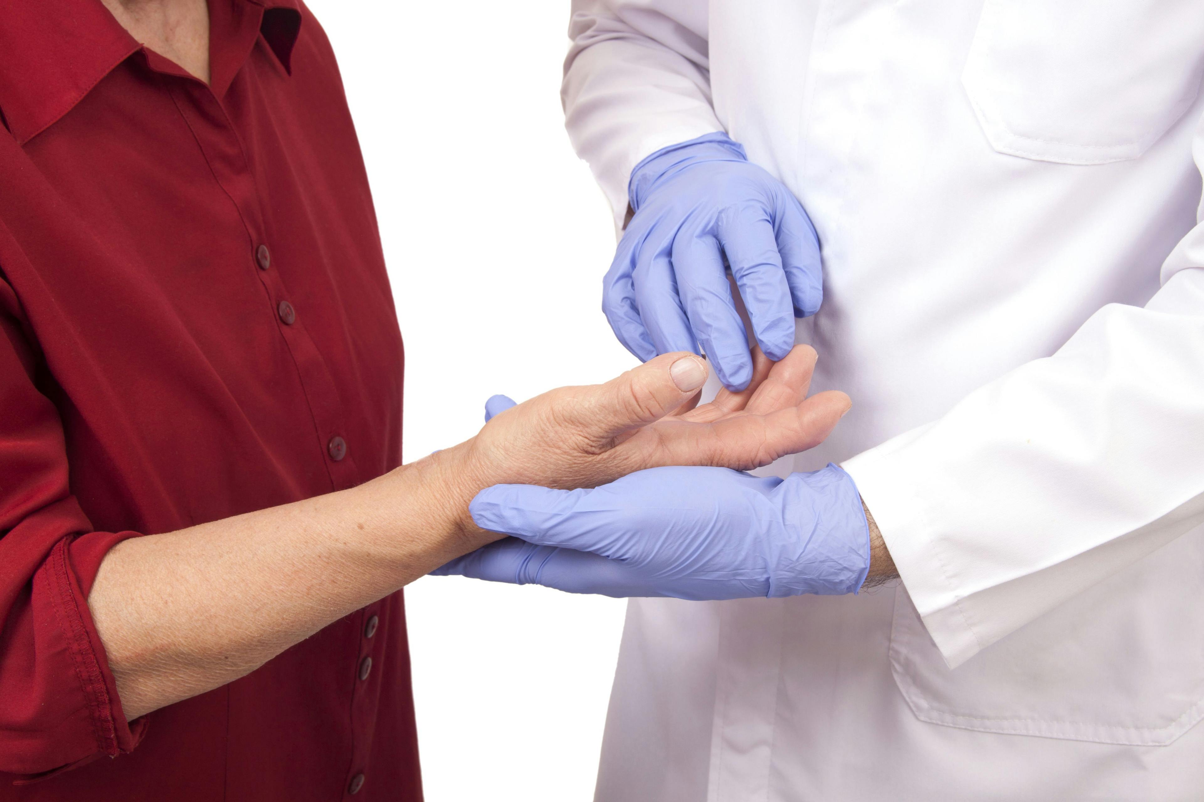 Physician checking joint swelling of patient.